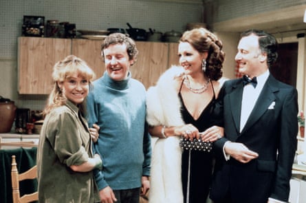 The four actors in The Good Life standing in the Goods’ kitchen - with Penelope Keith in a black evening dress, white fur stole and an elaborate hairdo
