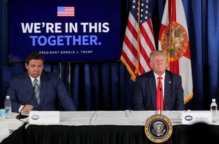 Men sit at desk with flags behind them
