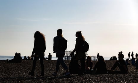 Silhouette figures on Brighton seafront in East Sussex, UK.
