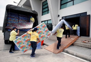 Bangkok. Workers carry mattresses prepared as beds for patients amid the surge of COVID-19