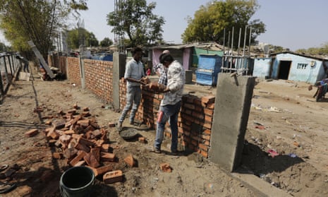 Workers construct a wall in front of a slum ahead of Donald Trump’s visit in Ahmadabad, India.