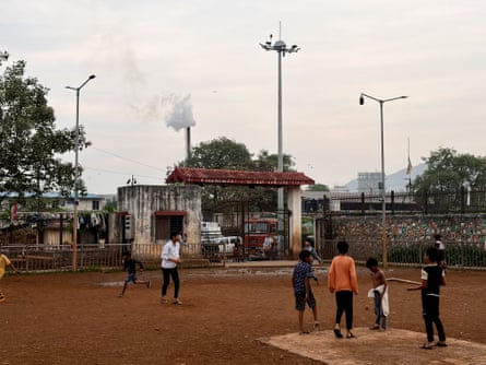 Smoke rises from a chimney as children play nearby