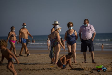 People wear face masks at the beach in Barbate, Cadiz province, south of Spain, on Saturday, 25 July, 2020.