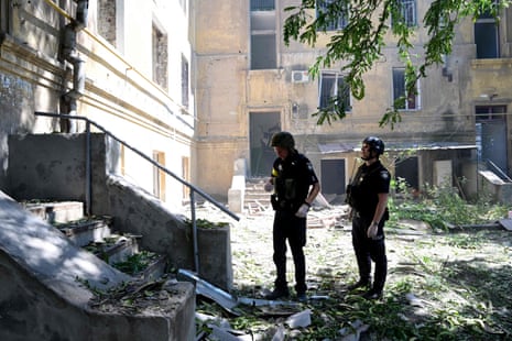 Police officers try to enter in a building to search for injured persons after an air strike hit the courtyard between the hotel Industria and civilian residences in the centre of Kramatorsk.