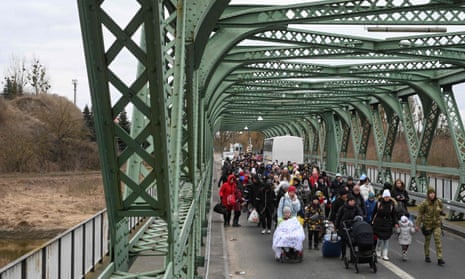 Ukrainian refugees walk across a bridge to Poland.