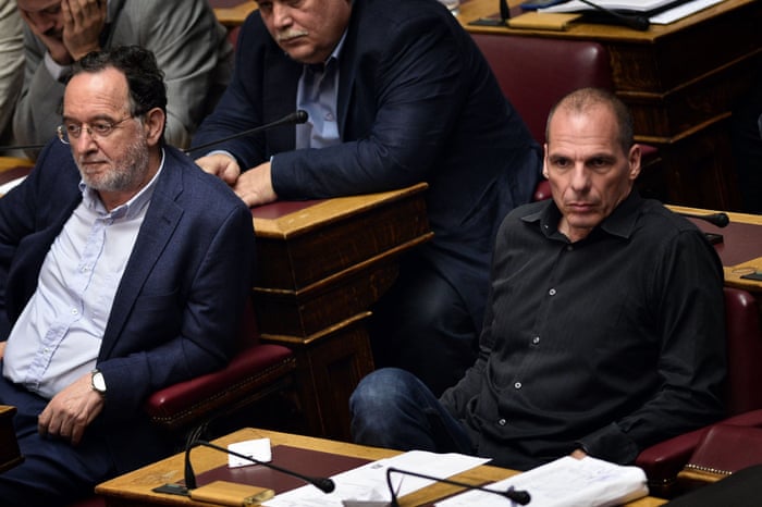 Former Greek Finance Minister Yianis Varoufakis (R) sits next to former Greek Energy Minister Panagiotis Lafazanis (L) during the vote at the Greek parliament in Athens early on July 23, 2015