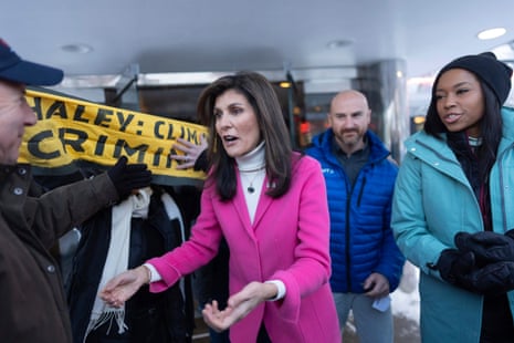 Nikki Haley moves past climate protesters to greet supporters as she moves to a waiting vehicle after a campaign event at Drake Diner, in Des Moines, Iowa.