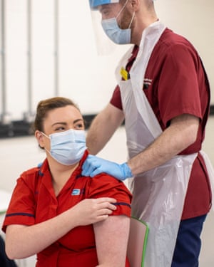 Joanna Sloan is congratulated by her colleague Conor McDowell after becoming the first person in Northern Ireland to receive the vaccine, at the Royal Victoria hospital in Belfast.