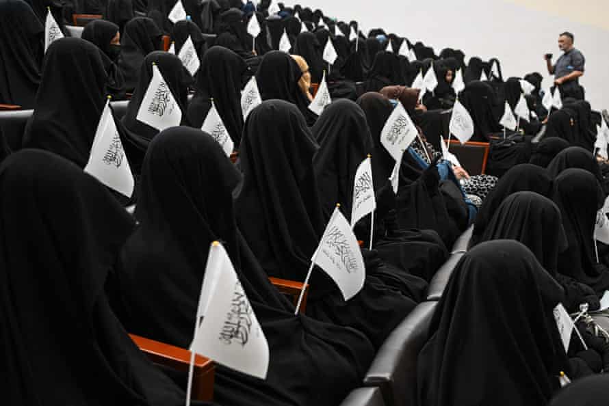 Veiled students hold Taliban flags as they listen a speaker before a pro-Taliban rally at the Shaheed Rabbani Education University in Kabul on 11 September.