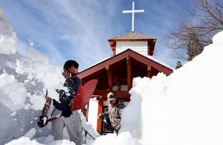 Residents shovel snow from in front of a church after winter storms dropped more than 100in of snow in the San Bernardino mountains.