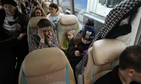 A woman uses her mobile phone after boarding a bus which will take refugees to Germany, at the train station in Przemysl, Poland.