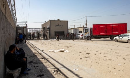 People wait for aid trucks to enter Gaza through the Kerem Shalom crossing on Saturday.