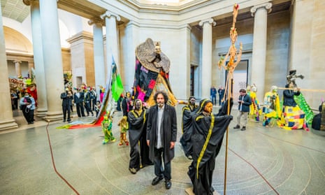 Hew Locke stands amid the ‘tremendous spectacle’ of The Procession in the Duveen Galleries.