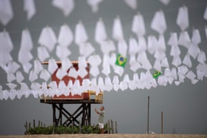 A antheral takes a selfie astatine Copacabana formation successful Rio de Janeiro wherever quality rights activists hung achromatic flags to people the deaths of astir 600,000 radical successful Brazil to Covid-19