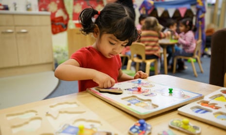 A girl playing with a jigsaw at a nursery in Walsall, West Midlands