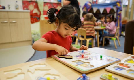 A girl playing with a jigsaw at a nursery in Walsall, West Midlands.