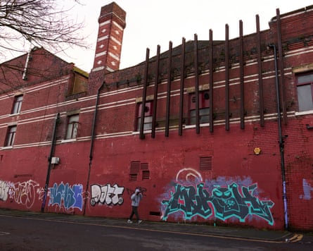 The exterior of the red brick hippodrome today, showing iron poles and graffiti