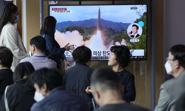 Les navetteurs de la gare de Séoul regardent les informations télévisées sur le lancement de missiles nord-coréens sur grand écran