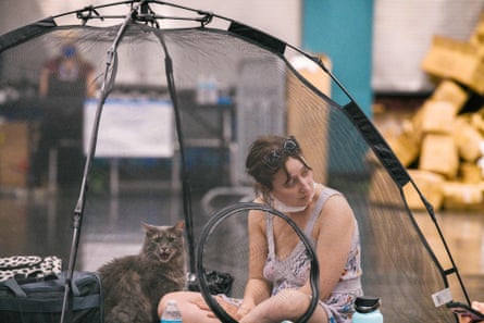 Una mujer y su gato se refugian dentro de una carpa en la estación de enfriamiento del centro de convenciones de Oregon en Oregon, Portland, en junio de 2021.
