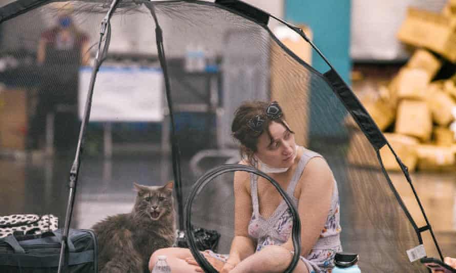 A woman and her cat rest inside a tent at the Oregon Convention Center cooling station in Portland, US.
