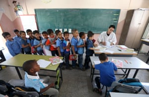 Mohammed Zurob marks a book for students at Taha Huseen elementary school