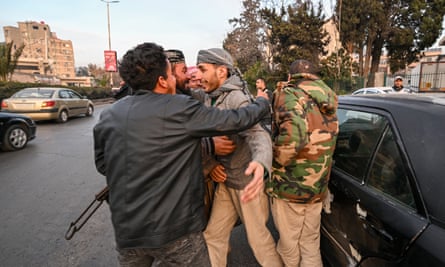 People greet each other on a street in Damascus after rebels entered the Syrian capital.
