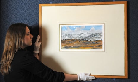 Exhibition Curator Lauren Porter adjusts a watercolour painted by Prince Charles in 2012 entitled Lochnagar from the Gelder Cottage