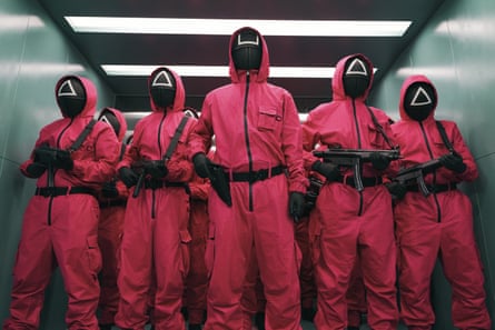 masked, armed figures in red overalls