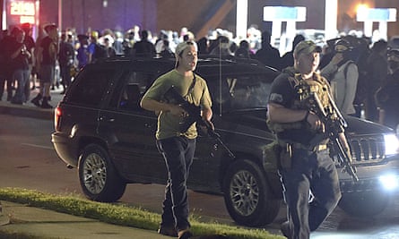 Kyle Rittenhouse, left, walks along Sheridan Road in Kenosha, Wisconsin, with another armed civilian during the protest over the police shooting of Jacob Blake on 25 August 2020.
