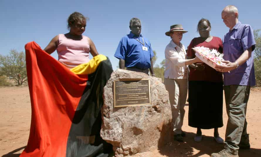 Jeannie Herbert and Teresa Ross Napurrurla reveal a plaque to mark the massacre, accompanied by Harry Nelson, Kumanjayi Brown and the great niece of George Murray, Lisa Dale-Hallett, and her husband, Martin