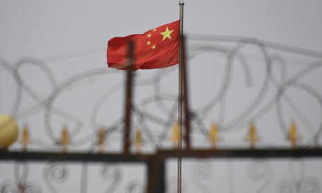 The Chinese flag behind razor wire at a housing compound in Yangisar, south of Kashgar, in China’s western Xinjiang region.