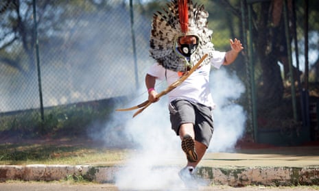 Indigenous Brazilians from different ethnic groups take part in a protest for land demarcation and against President Jair Bolsonaro’s government<br>Indigenous Leader Kretan Kaingang of the Kaingang tribe kicks a tear gas canister fired by police forces during a protest for land demarcation and against President Jair Bolsonaro’s government, in front of National Congress in Brasilia, Brazil June 22, 2021. REUTERS/Ueslei Marcelino