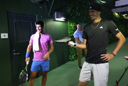 Carlos Alcaraz and Alexander Zverev watch on a TV monitor in the players tunnel after running in for cover from a swarm of bees.