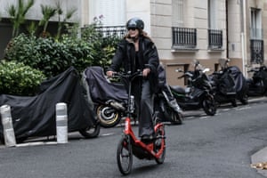 Carla Bruni riding an unusual standing-bicycle down a hill