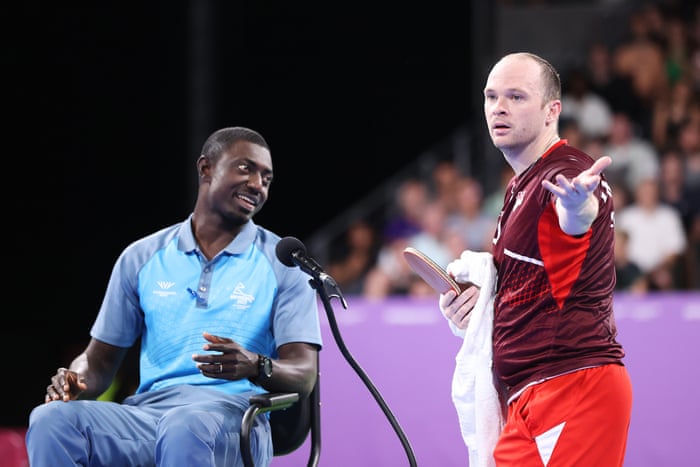 Paul Drinkhall of England talks with the match umpire.