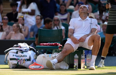 Taylor Fritz stretches retired his injured knee during a alteration of ends.