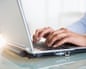 Mixed race businesswoman working on laptopE5A7NB Mixed race businesswoman working on laptop
