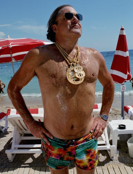 Man on beach wearing medallions