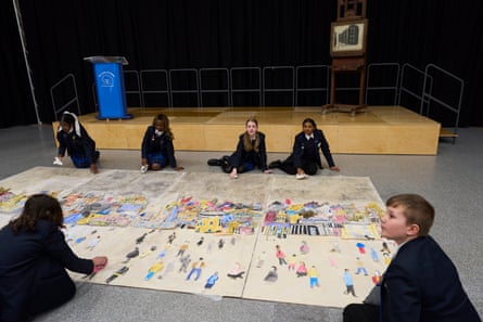 Children sat on floor creating an artwork on paper