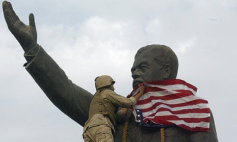 A US marine covering a statue of Saddam Hussein with the American flag in Baghdad, April 2003