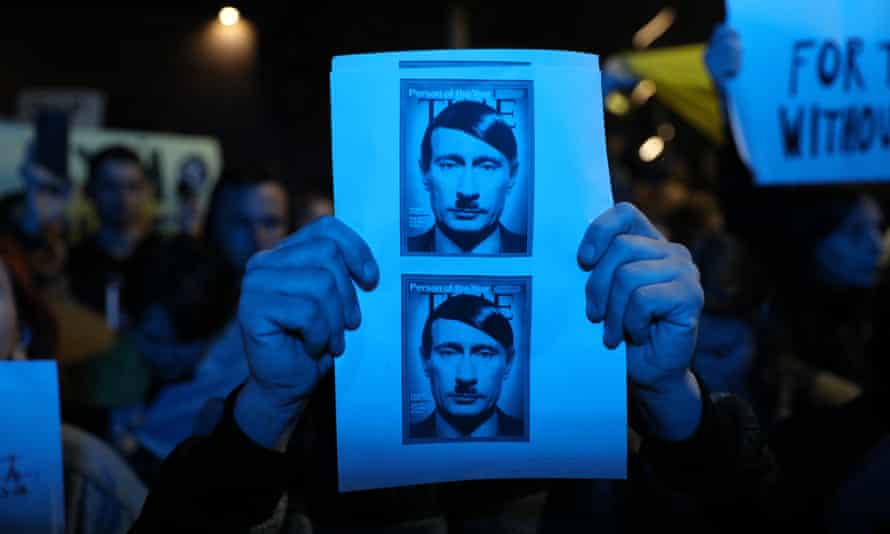 person holding a photo showing Putin with a Hitler mustache