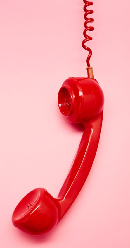 A red retro phone received on pink background