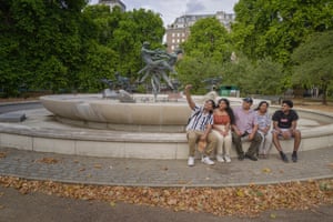A family sitting on an empty fountain in Hyde Park