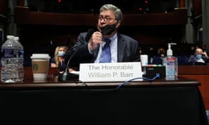 U.S. Attorney General William Barr removes his mask after a break in a House Judiciary Committee hearing on Capitol Hill, in Washington.