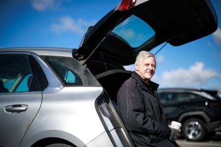 Kevin Grieve sits on the sill of his open car boot