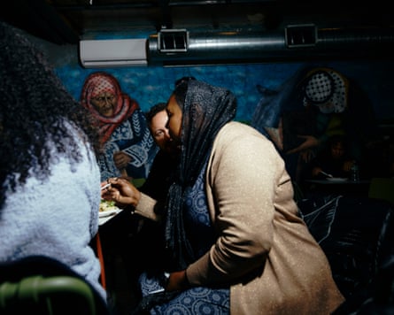 Two people talk to each other while eating.