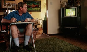 Man eating lunch watching cricket on Television