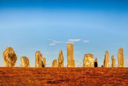 The standing stones of Callanish seen against a clear blue sky on an autumn evening.