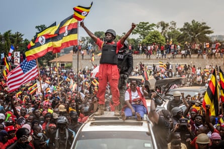 Bobi Wine, standing on top of a car, waves a Ugandan flag during a campaign rally in Mukono, 9 January 2026