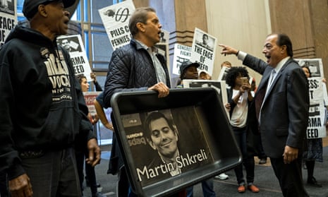 Carrying an image of Turing Pharmaceuticals CEO Martin Shkreli in a makeshift cat litter pan, activists are asked to leave a lobby in New York.